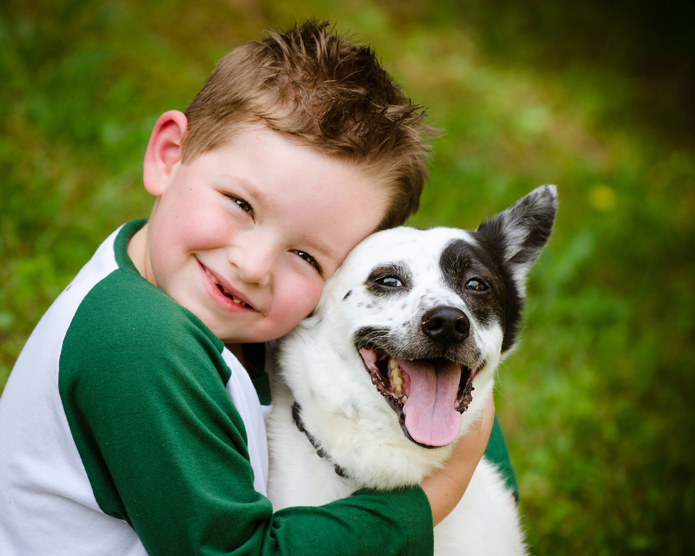 young boy hugging a dog